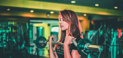 woman lifting black and gray barbell