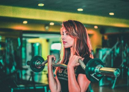 woman lifting black and gray barbell